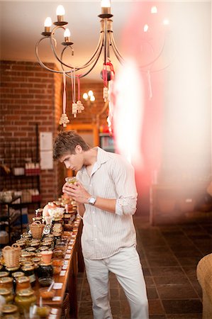 showing - Man smelling preserves in grocery Stock Photo - Premium Royalty-Free, Code: 614-06624088