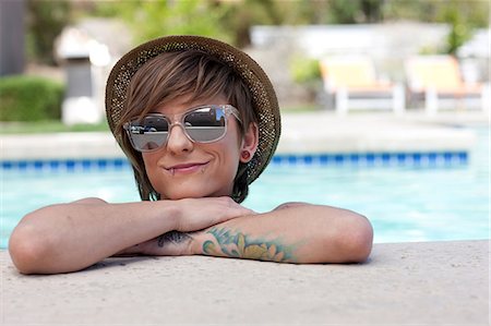 Woman leaning on edge of pool Stock Photo - Premium Royalty-Free, Code: 614-06624295