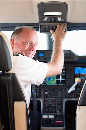 pilot - Pilot smiling in airplane cockpit Stock Photo - Premium Royalty-Free, Code: 614-06624339