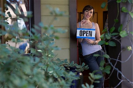 Woman holding open sign in store Stock Photo - Premium Royalty-Free, Code: 614-06624454