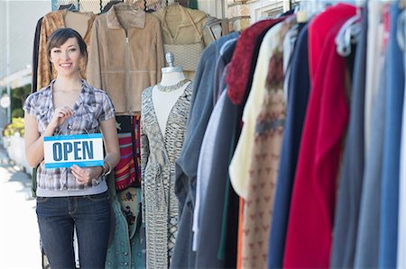 Woman holding open sign by store Stock Photo - Premium Royalty-Free, Code: 614-06624451