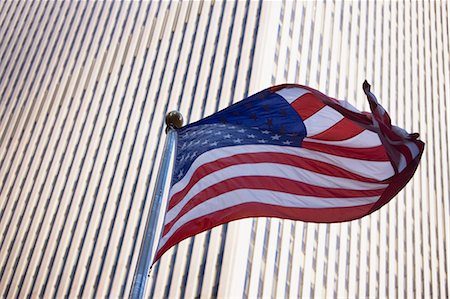 flag pole - American flag flying by city skyscraper Stock Photo - Premium Royalty-Free, Code: 614-06624664