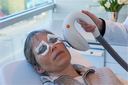 eye patch - Doctor giving patient sunspot treatment Stock Photo - Premium Royalty-Free, Code: 614-06624810