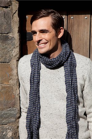 Smiling man wearing scarf outdoors Fotografie stock - Premium Royalty-Free, Codice: 614-06625059