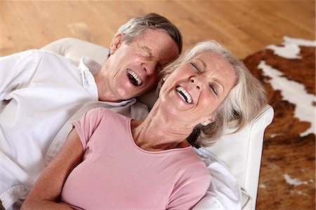 senior adult relaxing portrait not child - Older couple laughing on sofa Stock Photo - Premium Royalty-Free, Code: 614-06625175