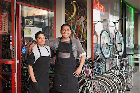 Mechanics smiling outside bicycle shop Foto de stock - Sin royalties Premium, Código: 614-06625237