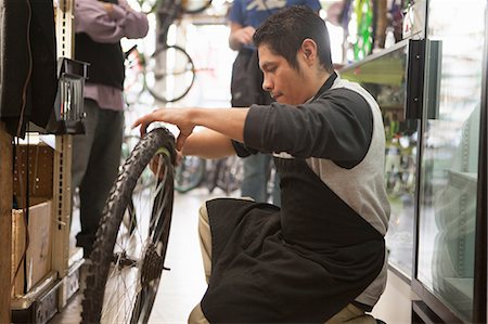 Mechanic working in bicycle shop Stock Photo - Premium Royalty-Free, Code: 614-06625232