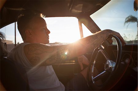 driving car side - Man driving vintage car at sunset Stock Photo - Premium Royalty-Free, Code: 614-06625256