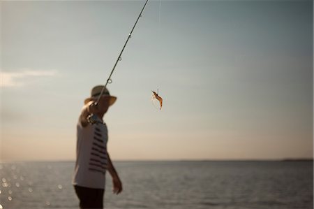 Man displaying lure on fishing line Photographie de stock - Premium Libres de Droits, Code: 614-06625252