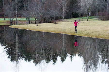 freedom (feeling) - Woman running by still rural lake Stock Photo - Premium Royalty-Free, Code: 614-06625307