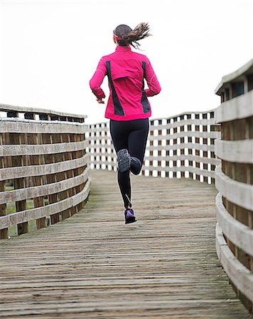 pony tail - Woman running on wooden dock Stock Photo - Premium Royalty-Free, Code: 614-06625314