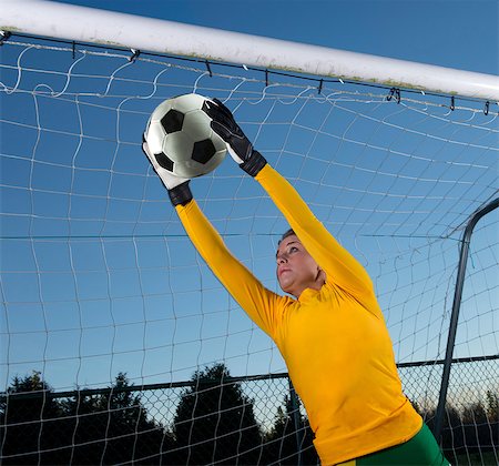 football skill - Soccer player catching ball in goal Stock Photo - Premium Royalty-Free, Code: 614-06625334