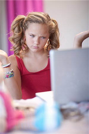 pigtails - Confused girl using laptop Stock Photo - Premium Royalty-Free, Code: 614-06623445