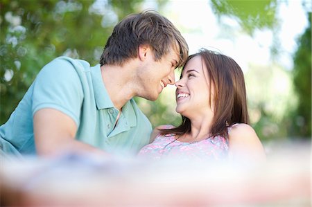 person rubbing nose - Smiling couple relaxing in park Stock Photo - Premium Royalty-Free, Code: 614-06623547