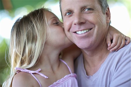 smiling portrait looking away - Girl kissing father outdoors Photographie de stock - Premium Libres de Droits, Code: 614-06623622