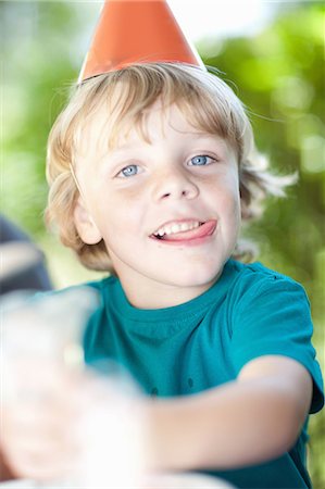 Boy wearing party hat outdoors Stock Photo - Premium Royalty-Free, Code: 614-06623765