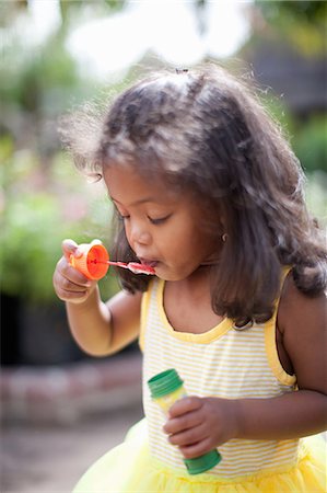 Girl blowing bubbles outdoors Stock Photo - Premium Royalty-Free, Code: 614-06623919