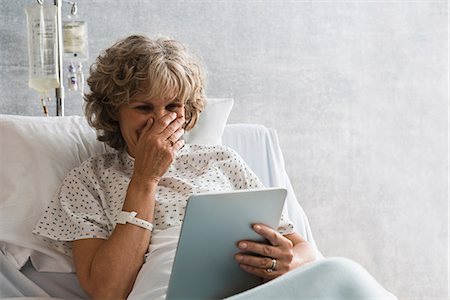 skype - Female hospital patient with digital tablet, laughing Stock Photo - Premium Royalty-Free, Code: 614-06718077