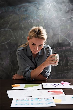 simsearch:614-06718107,k - Woman looking at papers with cup of coffee Stock Photo - Premium Royalty-Free, Code: 614-06718135