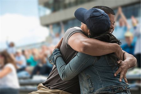 Couple hugging at sports game Foto de stock - Sin royalties Premium, Código: 614-06718187