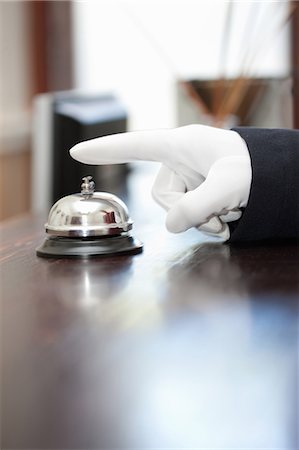 ring the bell - Bellhop ringing bell in hotel lobby Stock Photo - Premium Royalty-Free, Code: 614-06718495