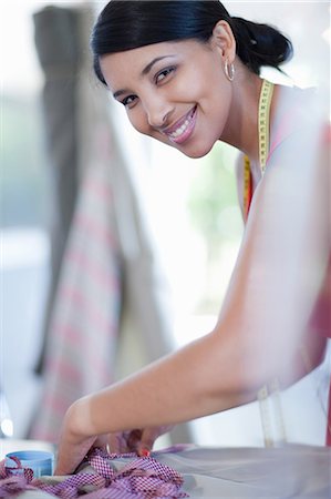 seamstress - Dressmaker smiling in studio Stock Photo - Premium Royalty-Free, Code: 614-06718510