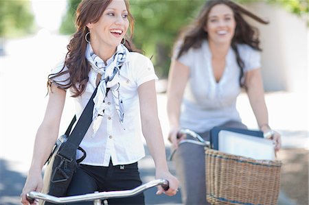 person in a basket of a bike - Women riding bicycles in park Stock Photo - Premium Royalty-Free, Code: 614-06718570