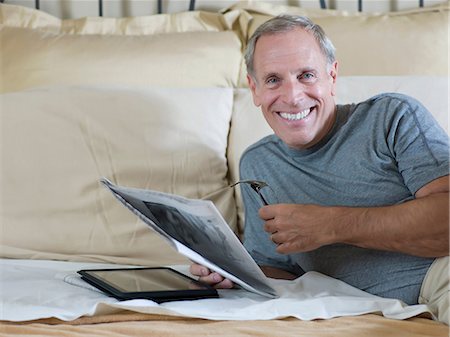 simsearch:625-00801205,k - Older man reading newspaper on bed Stock Photo - Premium Royalty-Free, Code: 614-06718900