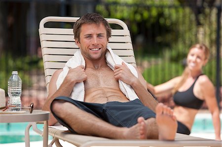 swimming trunks - Man relaxing in lawn chair by pool Stock Photo - Premium Royalty-Free, Code: 614-06719026