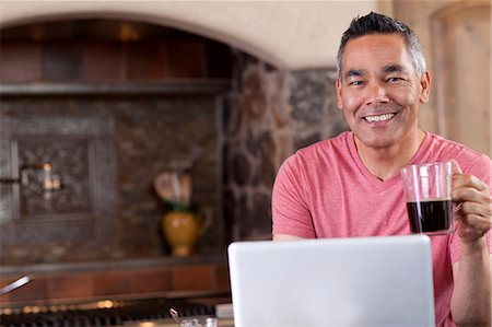 Man using laptop at breakfast Stock Photo - Premium Royalty-Free, Code: 614-06719058