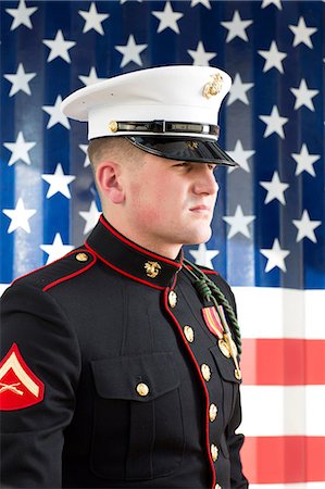 Serviceman in dress blues by US flag Stock Photo - Premium Royalty-Free, Code: 614-06719186