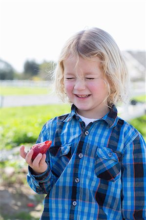 strawberry blonde hair - Boy eating strawberry outdoors Stock Photo - Premium Royalty-Free, Code: 614-06719226