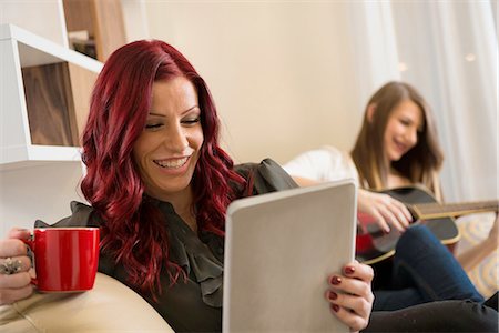 Woman using tablet computer on sofa Stock Photo - Premium Royalty-Free, Code: 614-06719307