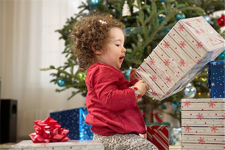 Toddler girl opening Christmas gifts Stock Photo - Premium Royalty-Free, Code: 614-06719301