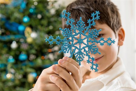 snowflakes  holiday - Boy holding blue snowflake decoration Stock Photo - Premium Royalty-Free, Code: 614-06719328