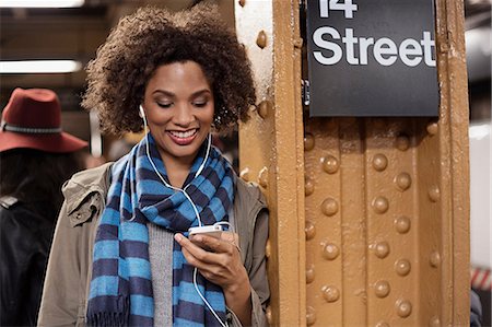 Woman listening to earphones at station Photographie de stock - Premium Libres de Droits, Code: 614-06719734