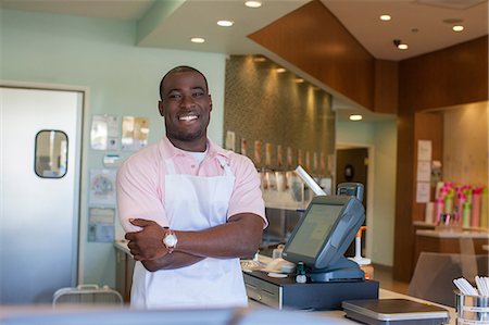 small business - Cashier smiling behind counter Stock Photo - Premium Royalty-Free, Code: 614-06719801