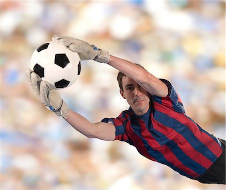 Soccer player catching ball in air Stock Photo - Premium Royalty-Free, Code: 614-06719869