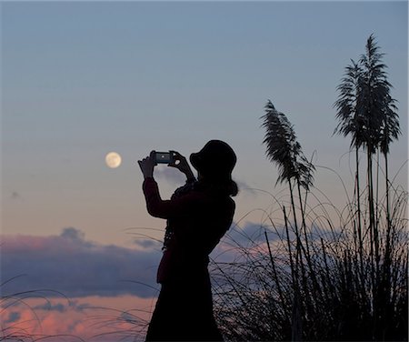 Woman taking picture of moon Stock Photo - Premium Royalty-Free, Code: 614-06719910