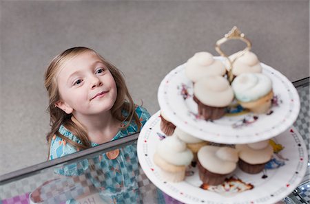 Girl admiring cupcakes in bakery Stock Photo - Premium Royalty-Free, Code: 614-06719944