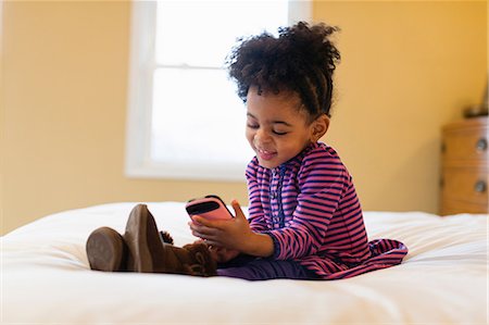 simsearch:614-06537448,k - Girl playing with cell phone on bed Stock Photo - Premium Royalty-Free, Code: 614-06720120