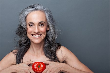 Mature woman holding red tomato Stock Photo - Premium Royalty-Free, Code: 614-06814173