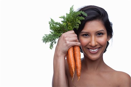 Young woman holding bunch of carrots Stock Photo - Premium Royalty-Free, Code: 614-06814199