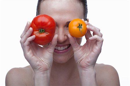 simsearch:614-06814236,k - Young woman covering eyes with red and yellow tomato Stock Photo - Premium Royalty-Free, Code: 614-06814227