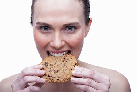 energy consumption - Young woman biting cookie Stock Photo - Premium Royalty-Free, Code: 614-06814228
