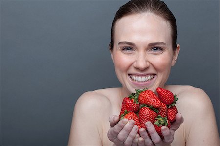 simsearch:614-06814236,k - Young woman holding strawberries Stock Photo - Premium Royalty-Free, Code: 614-06814223