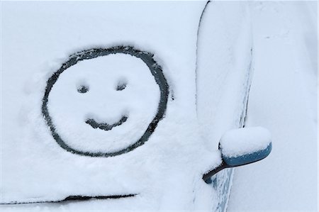 Smiley face drawn in snow on car windscreen Stock Photo - Premium Royalty-Free, Code: 614-06813436