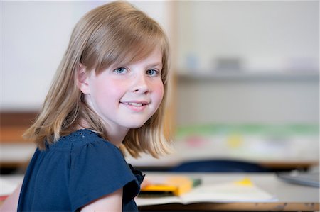 simsearch:614-06895765,k - Schoolgirl sitting at desk in school and smiling, portrait Stock Photo - Premium Royalty-Free, Code: 614-06895764