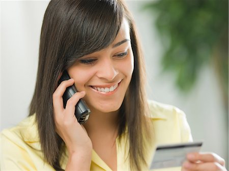 person on phone with credit card - Young woman using credit card over the phone Stock Photo - Premium Royalty-Free, Code: 614-06895800