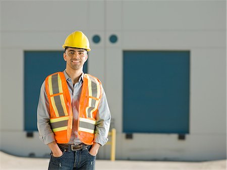 Mid adult construction worker with hand sin pockets, portrait Stock Photo - Premium Royalty-Free, Code: 614-06895840